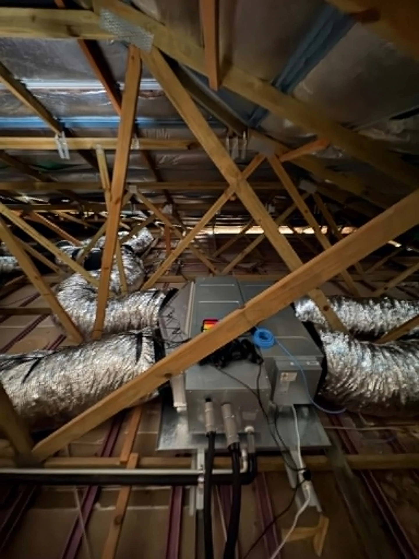 Ducted air conditioning fan coil and insulated ductwork installed in a roof space